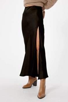 Make a statement in SOPHIE RUE's Manhattan Maxi Skirt - the ultimate all-season wardrobe staple! This sky-high, bias cut skirt features a leg baring, high side slit and a comfy elastic waistband that allows for easy movement. It's the perfect way to turn heads with its timeless maxi length and slight flare at the hem. PRO TIP: Try pairing this skirt with the TRIOMPHE TOP for an easy-to-wear-anywhere fall-ready look! **Sizing notes: This style runs TTS. Model is 5'8" and wearing a size S. MATERIA Black Manhattan, Bias Cut Skirt, Midi Length Skirts, Satin Skirt, Sky High, Black Skirt, Black Satin, Manhattan, Fabric Care