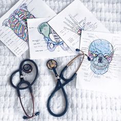 three medical diagrams and a stethoscope laying on top of a white blanket