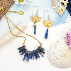 Step into the realm of  our Raw Kyanite Resort Wear Jewelry Set, a masterpiece of natural elegance and island bohemian charm. This captivating set features raw slices of beautiful blue kyanite, forming a stunning crystal ray that adorns your neck with grace and sophistication. The earrings boast a unique silver and brass mix metal design, with a hand-hammered brass half moon embracing a silver new moon, accentuated by a dangling kyanite slice below. Embrace the allure of ethical jewelry with this original handmade set, crafted with fair trade practices to honor both craftsmanship and the environment. Elevate your style with this mesmerizing jewelry set, perfect for resort wear and any occasion that calls for a touch of ethereal beauty. Bohemian Brass Jewelry For The Beach, Bohemian Brass Jewelry For Beach, Bohemian Gold Jewelry For Beach, Bohemian Gold Beach Jewelry, Nature-inspired Gold Jewelry With Raw Stone, Bohemian Brass Jewelry With Natural Stones, Artisan Gold Jewelry For The Beach, Artisan Gold Jewelry For Beach, Artisan Gold Beach Jewelry