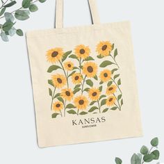 This cute Kansas floral tote bag features Kansas's state flower, the 'wild sunflower', making it perfect for use as a shopping tote for farmers' market hauls, the beach, school, books, library, or everyday adventures. The sturdy construction ensures it can handle your essentials with ease. Customize or personalize it to give as a bridesmaid gift, bachelorette gift, or teacher gift. With our 'original' hand-drawn floral art, this floral cotton canvas tote bag becomes a great memento of the places Paint Canvas Bag, Hand Painted Tote Bags Art, Tote Bag Decoration, Sunflower Making, Kansas State Flower, Kansas Travel, Sunflower Tote Bag, Painted Tote Bag, Painted Canvas Bags