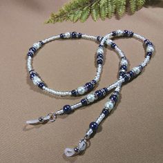 "This Glasses chain has soft blue and white pearl finish glass beads (2 sizes on the blue ones!) and silver rondelles with iridescent mini rhinestones. The glass seed beads are clear with white inserts. It's a sweet gift for someone special to you! Length - 28\" (68.58 cm) Weight - 1.34 oz. (30 grams) Multi-strand stringing wire Silicone ends" Beaded Metal Glasses Chains For Party, Metal Beaded Glasses Chains For Party, Elegant Blue Beaded Necklace With Adjustable Chain, Blue Beaded Chain Glasses Chains With Round Beads, Adjustable Silver Beaded Necklace With Pearl Chain, Blue Beaded Glasses Chains, Blue Glasses Chains With Round Beaded Chain, Blue Glasses Chain With Colorful Beads For Gift, Blue Glasses Chain With Colorful Beads As Gift