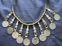 This is an unsigned choker or necklace with coin type embellishments. Most of them look more silver or pewter tone but a few look rather brassy. Closes via a button on the back. This measures about 16.25 inches long, so your neck would need to be smaller to wear this as a choker. Very primitive tribal boho looking. More vintage jewelry here: https://www.etsy.com/shop/badkittyvintagefinds?ref=hdr_shop_menu§ion_id=14398871 Bohemian Coin Necklace, Afghani Jwellary, Coin Choker, Ethnic Style, Coin Necklace, Jewelry Diy, Ethnic Fashion, Boho Necklace, Chain Styles