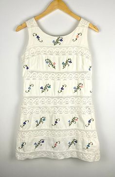 Vintage 1960's Maya de Mexico White Crochet Lace Tiered Shift Dress with Floral Embroidery * Beach Bridal * Cotton * Sleeveless Mini * Vintage tank top mini dress in white with crochet lace and embroidered flowers * Cute for a summer or beach wedding * Scoop neck * Shift dress * Zipper closure on back * Dress has been shortened, fabric is stitched inside and can be unstitched to make longer - see image * 100 % cotton * Fits like a size extra small Measurements (flat): Bust: 17 in Waist: 16 in Hi Sleeveless Summer Embroidered Lace Dress, Sleeveless White Dress With Broderie Anglaise, Sleeveless Embroidered Dress With Lace Trim For Spring, Sleeveless Broderie Anglaise Dress For Garden Party, Vintage Sleeveless Crochet Dress, Sleeveless Cotton Embroidered Dress For Garden Party, Spring Sleeveless Crochet Dress With Lace Patchwork, Sleeveless Floral Embroidered Dress For Vacation, Sleeveless Embroidered Floral Dress For Vacation