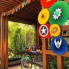 an outdoor party with paper fans and decorations on the outside wall, including captain america's shield