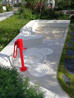 a red object sitting on top of a cement slab