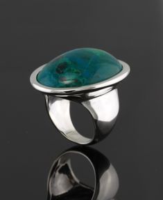 30x22mm oval  chrysocolla cabochon set in sterling silver ring.  Available with any type of gemstone. *Cabochon *Flat *Buff top *Rose cut ( depending on availability)  This ring is high polished and is also available with textured surface. Please indicate your ring size. Also available in gold.  Price in 14kt white or yellow gold $1050.00 Formal Oval Cabochon Turquoise Ring, Elegant Oval Turquoise Ring With Large Stone, Modern Oval Cabochon Dome Ring, Sterling Silver Turquoise Ring Oval Cabochon, Turquoise Oval Cabochon Ring With Polished Finish, Elegant Silver Turquoise Oval Cabochon Ring, Elegant Silver Turquoise Ring With Oval Cabochon, Modern Oval Turquoise Gemstone Ring, Elegant Turquoise Silver Ring With Oval Cabochon