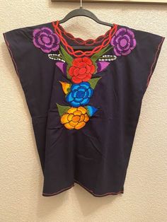 Beautiful Floral Embroidered Mexican Off blouse Colors vary on Floral Embroidery ~ One size fits Small / Medium ~ Round or Square neck ~ Multi-colored floral embroidery. ~ Handmade in Chiapas, Mexico ~ Measures Aprox.:     18" - 20" underarm x 20" - 21" long ~ Recommended hand wash & lay flat to dry Traditional Short Sleeve Embroidered Top With Tonal Embroidery, Traditional Short Sleeve Blouse With Tonal Embroidery, Multicolor Folk Embroidered Top With Embroidered Hem, Folk Style Multicolor Embroidered Top With Embroidered Hem, Traditional Multicolor Embroidered Blouse, Traditional Multicolor Blouse With Machine Embroidery, Mexican Blouse, Floral Blouse, Square Neck