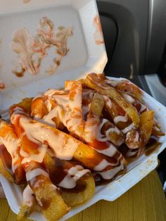 a plate with french fries covered in ketchup and sauce