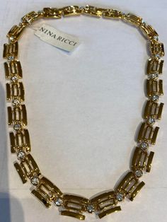 Nina Ricci Necklace. Triple 22kt gold w handset Swarovski crystals. Designer, Vintage, Canadian. 18 inches long 1/2 inches wide Gold Costume Jewelry Necklace With Sparkling Stones, Gold Hallmarked Necklaces For Evening, Gold-tone Rhinestone Jewelry For Formal Occasions, Formal Gold-tone Jewelry With Rhinestones, Formal Gold-tone Rhinestone Jewelry, Gold Necklace With Bling For Formal Occasions, Formal Gold Necklace With Bling, Formal Gold Crystal Necklaces, Formal Gold Bling Necklace