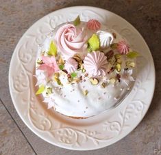 a white plate topped with a cake covered in frosting and flowers