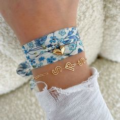 two bracelets with gold hearts on them are attached to a woman's wrist