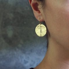 Early primitive crafting techniques have influenced the imperfect form and texture of this design. Bronze hand fabricated Orbit earring with cubic zirconia and gold filled ear wire. Bronze Cubic zirconia accent stones Gold Fill 1" Limited edition Handcrafted in the USA Fine Jewelry Brass Hammered Jewelry, Fine Jewelry Hammered Brass Jewelry, Gold Fusion Style Cubic Zirconia Earrings, Hammered Brass Fine Jewelry, Gold Cubic Zirconia Fusion Earrings, Handmade Gold Cubic Zirconia Earrings, Gold White Topaz Earrings In Fine Jewelry Style, Gold White Topaz Earrings For Gift, Fusion Style Hammered Round Jewelry