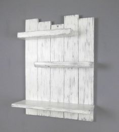 a white wooden shelf with two shelves on it