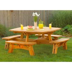 a picnic table with two benches in the grass