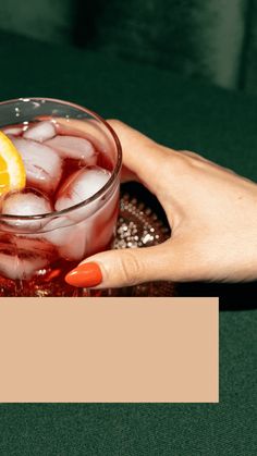 a person holding a glass with ice and lemon wedges