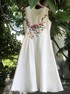 a white dress hanging from a tree outside