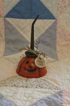 an orange pumpkin with a top hat on it's head is sitting on a quilt