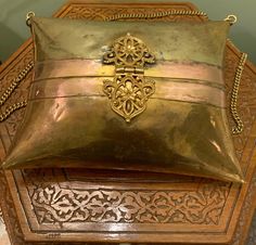 a gold pillow sitting on top of a wooden table