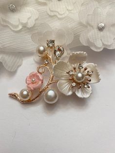 Brighten up any outfit with this beautiful faux pearl, rhinestone and resin cherry blossom brooch!  The cherry blossom flowers have dimension and texture and the faux pearl and teardrop rhinestone accents only add to the beauty! Brooch is approximately 1-7/8" tall and 2" wide. Not intended for children ages 13 and under.   Also, for many items we can accommodate large orders, so please send us a message. Elegant Wedding Pins With Handmade Flowers, Elegant Pink Wedding Brooches, Elegant Pink Flower Pins, Elegant Flower-shaped Wedding Pins, Elegant Wedding Pins With Flower Decoration, Elegant Flower Wedding Pins, White Flower Pins For Wedding, White Flower-shaped Wedding Pins, Flower Shaped Wedding Brooch Pin