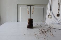 a pair of earrings is on a stand next to a door with jewelry hanging from it