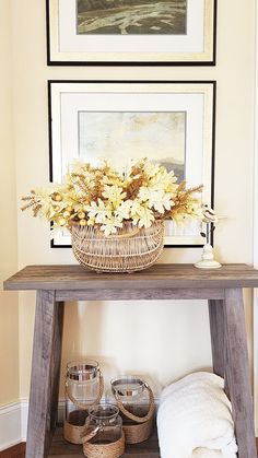 a wooden table topped with a basket filled with flowers next to two baskets on top of it