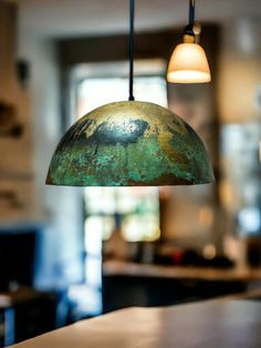 an old, rusty light fixture hangs from the ceiling above a bar in a kitchen