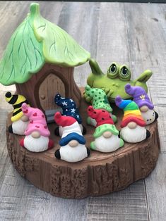 a group of small toy figurines sitting on top of a wooden table next to a tree stump