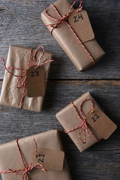 three wrapped presents tied with twine on wooden table