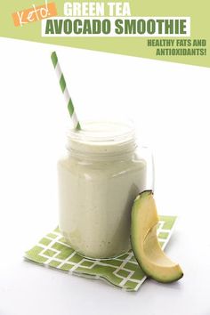 an avocado smoothie in a mason jar with a green striped straw next to it