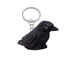 a black bird keychain is shown on a white background