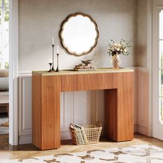 a wooden table with a mirror on top of it next to a basket and vase