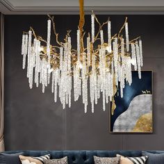 a living room with a couch and chandelier hanging from it's ceiling