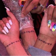 two women with matching tattoos on their arms and wrist are holding each other's hands