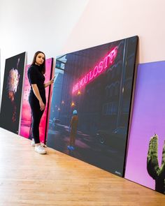 a woman is standing in front of some paintings