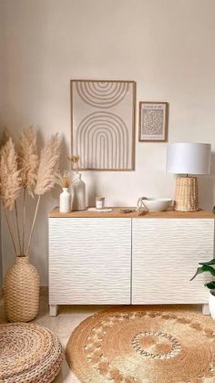 a living room area with rugs, potted plants and pictures on the wall