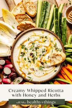 creamy whipped ricotta with honey and herbs on a platter surrounded by fresh vegetables