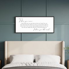 a bed with white sheets and pillows in front of a wall mounted art piece that reads, what do you mean?