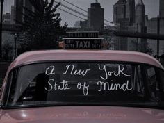 an old car with writing on the windshield in front of a cityscape that reads, a new york state of mind