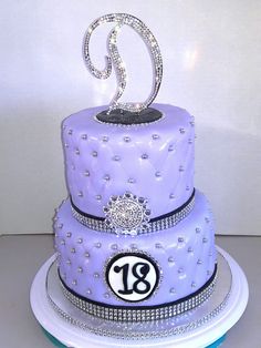 a three tiered cake decorated with diamonds and the number eighteen on it's side