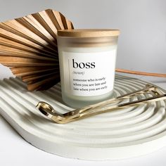 a candle with a wooden fan next to it on a white plate and gold handles