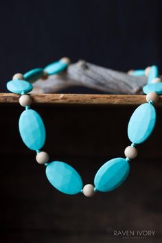 a blue necklace with white beads on it