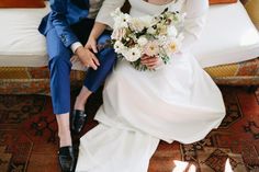 a bride and groom sitting on a couch with their feet propped up against each other