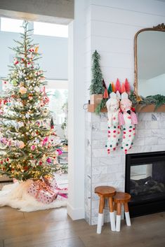 a decorated christmas tree sitting next to a fireplace