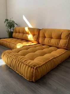 a large yellow couch sitting on top of a hard wood floor