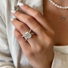 a woman's hand with a diamond ring on it