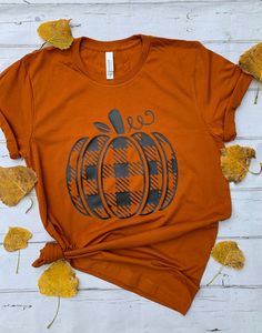 Plaid Pumpkin tee. Your choice of color for shirt.  Shirt is unisex and is true to size. Measurements in picture along with color options.  This soft bella canvas brand tee, baby-knit t-shirt looks great &  it fits like a well-loved favorite. Made from 100% cotton, except for heather colors, which contain polyester. I recommend washing inside out in cold water and tumble dry or air dry on low heat. Bella Canvas shirts have been hard to get in certain colors. If Bella Canvas is not available, you will get a different brand soft style tee. Trendy Fall Short Sleeve T-shirt, Trendy Short Sleeve Fall T-shirt, Casual Plaid T-shirt For Fall, Trendy Short Sleeve T-shirt For Fall, Fall Cotton Graphic Tee Shirt, Trendy Screen Print T-shirt For Fall, Orange Graphic Tee For Fall, Graphic Cotton Tee For Fall, Graphic Tee With Sublimation Print For Fall