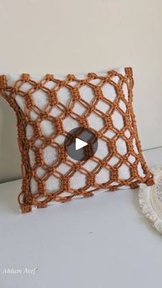 a crocheted pillow sitting on top of a table next to a doily