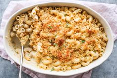 a white bowl filled with macaroni and cheese on top of a pink napkin