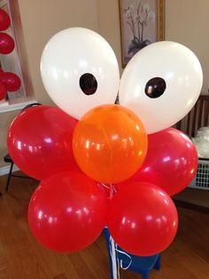 a bunch of balloons that have been placed in the shape of an orange and white face