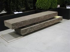 a stone bench sitting on top of a cement slab